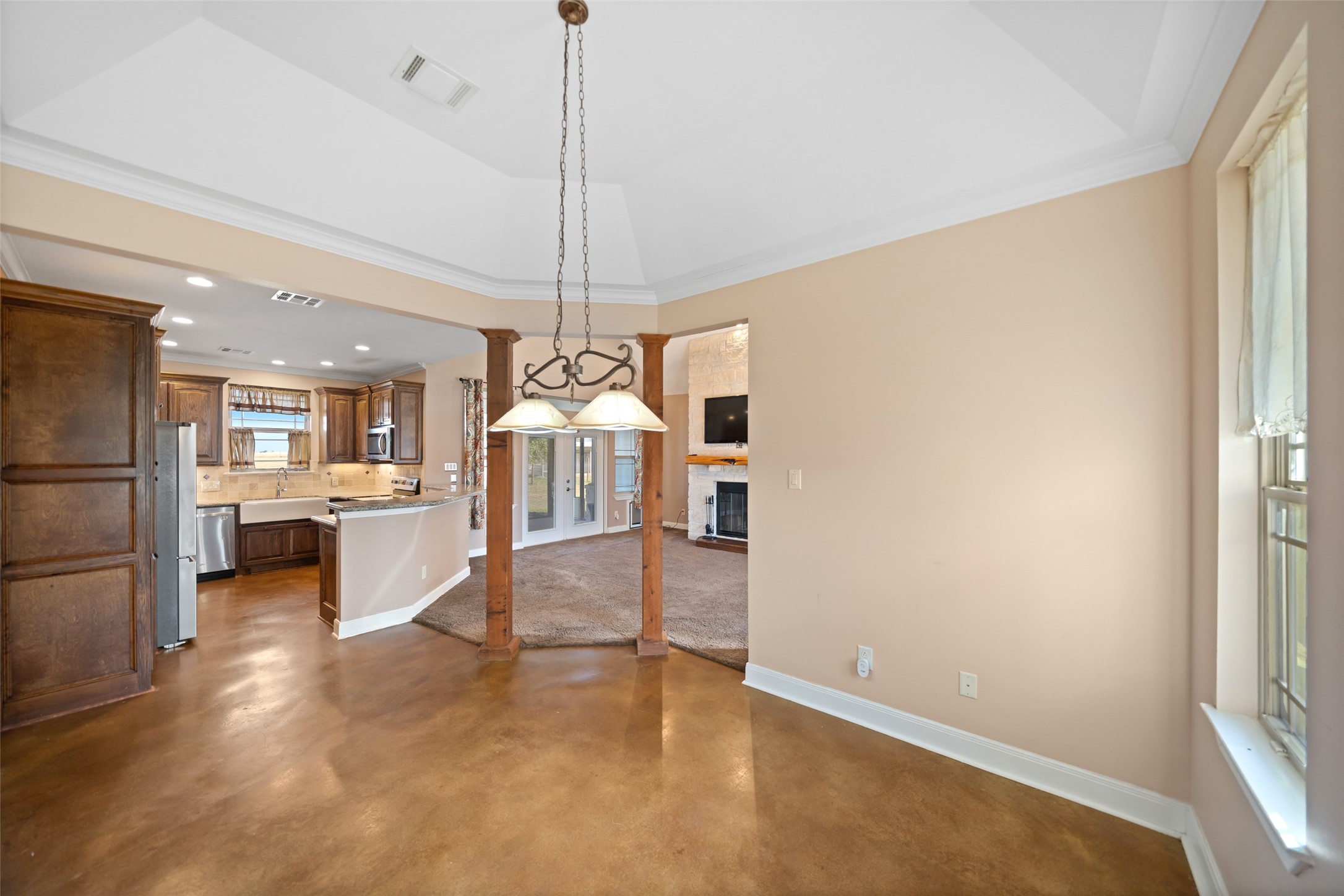 26752 Nelson Road Hempstead, TX 77445 - Photo 11 of 45 Formal dining area features polished concrete flooring, a tray ceiling with crown molding, and an elegant chandelier.