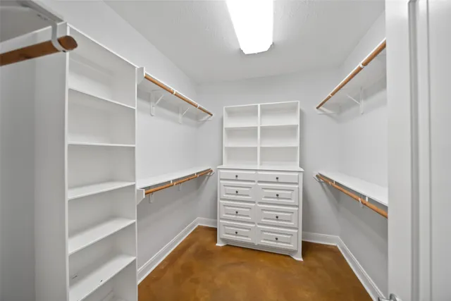 an empty room with ceiling fan and windows