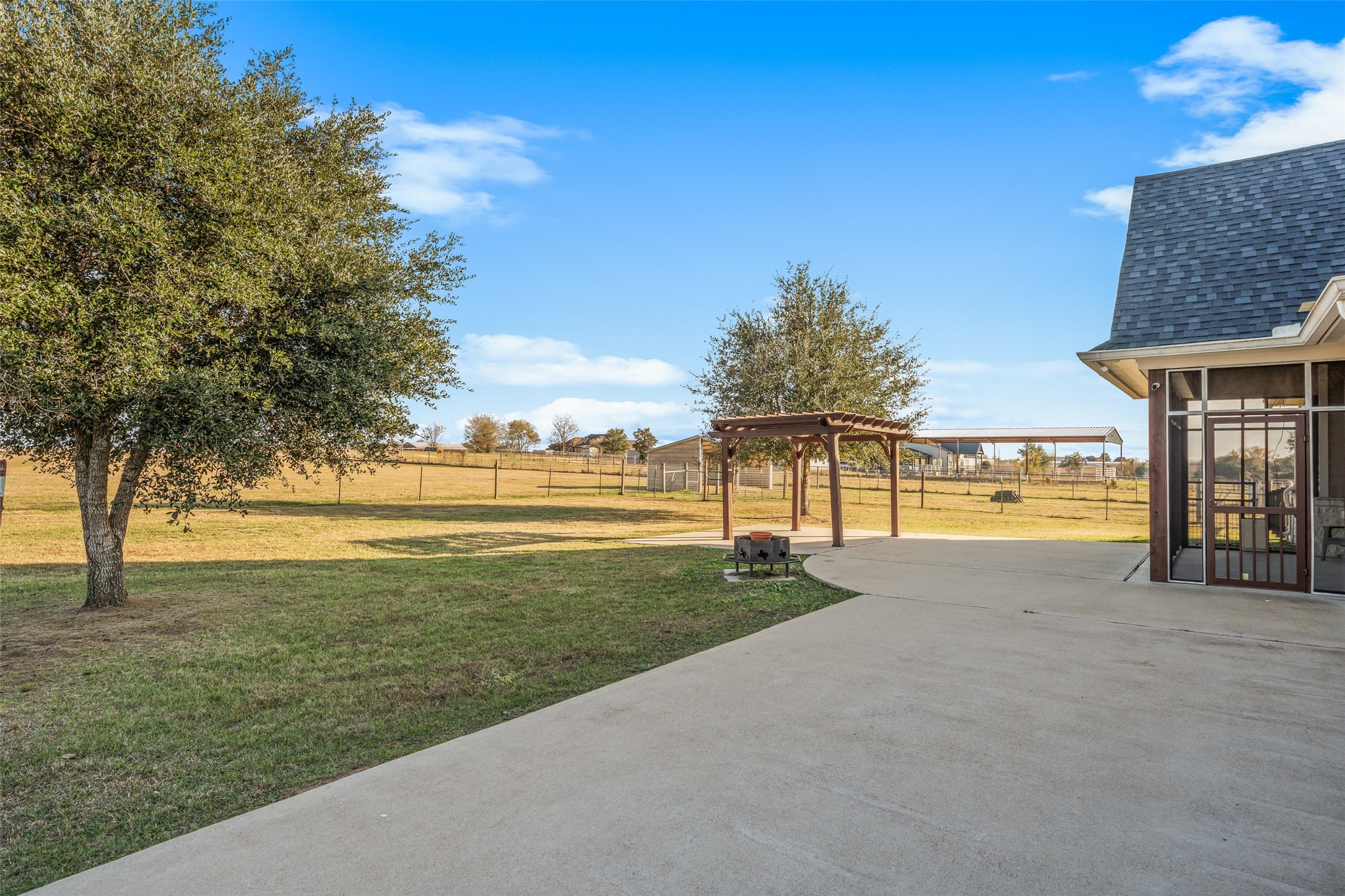 26752 Nelson Road Hempstead, TX 77445 - Photo 26 of 45 Concrete patio extends from the screened-in porch and leads to a pergola, creating defined outdoor spaces for relaxing or entertaining.