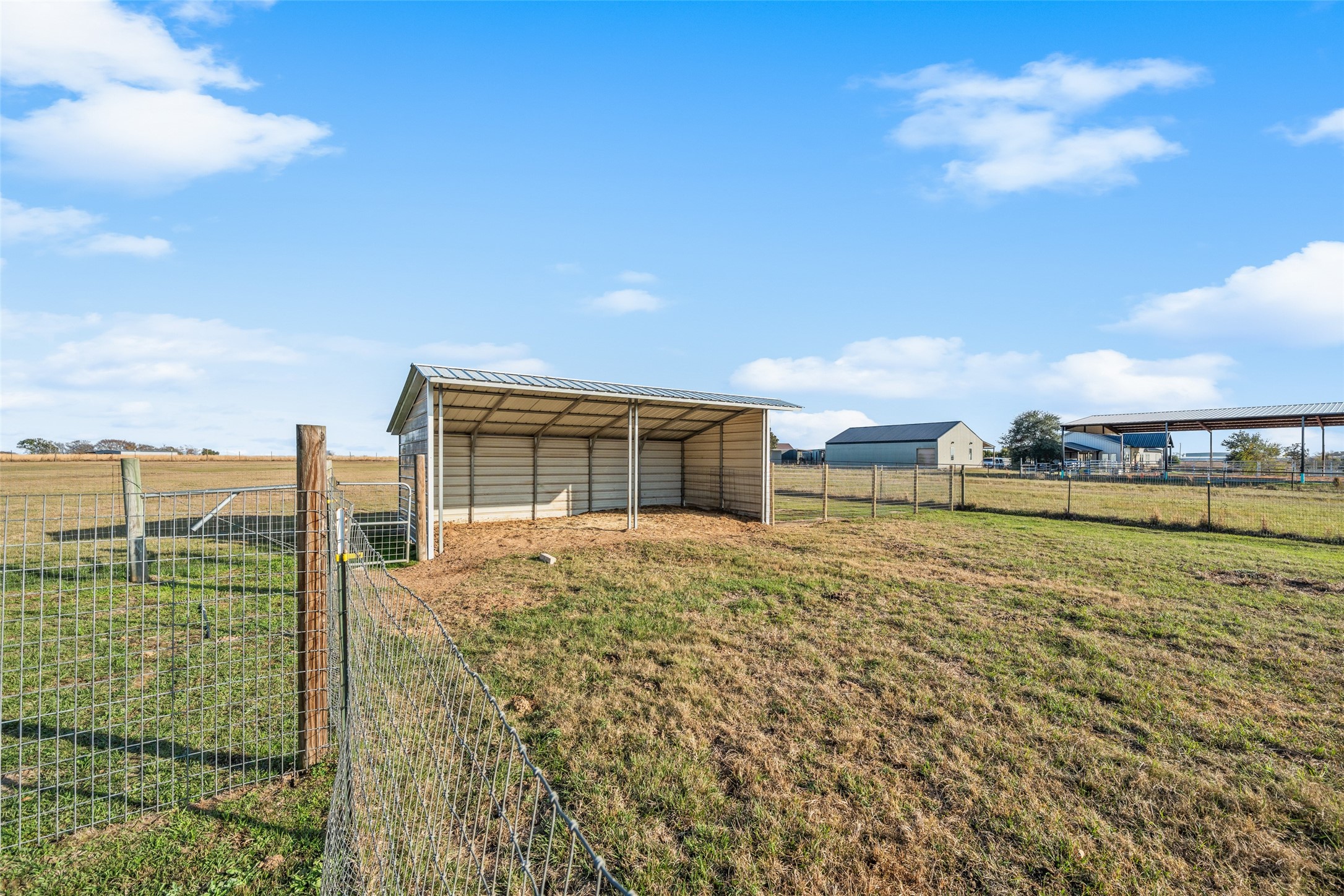 26752 Nelson Road Hempstead, TX 77445 - Photo 34 of 45 Metal run-in shelter located within fenced pasture, ideal for livestock or equipment storage.