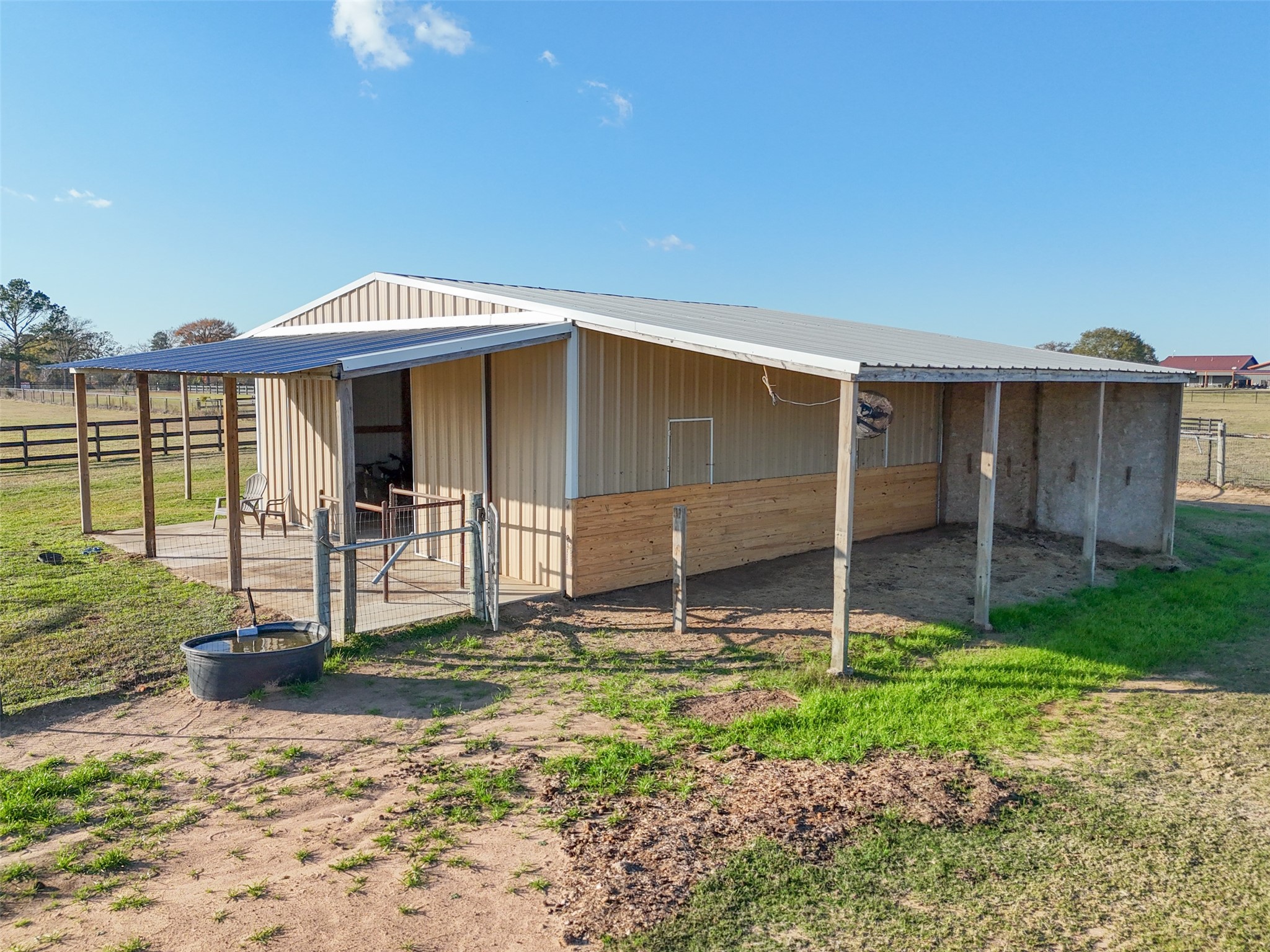 26752 Nelson Road Hempstead, TX 77445 - Photo 41 of 45 Side view highlights the barn’s covered overhang, fencing, and direct access to surrounding pasture.