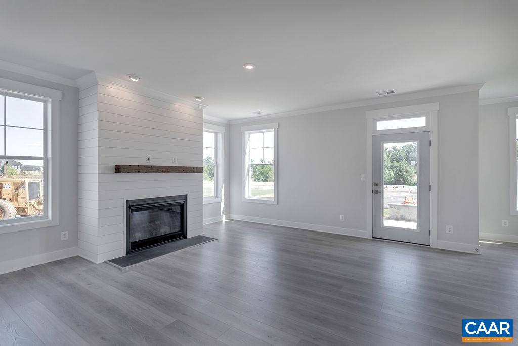 754 Arboleda Drive Crozet, VA 22932 - Photo 2 of 39 an empty room with wooden floor fireplace and windows