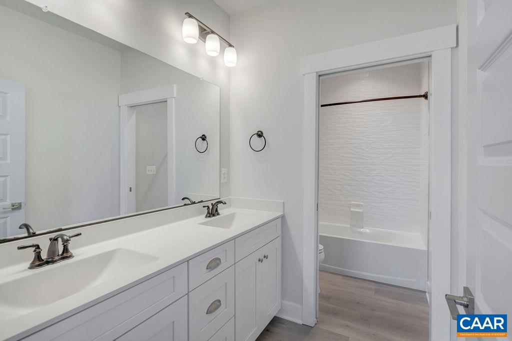 754 Arboleda Drive Crozet, VA 22932 - Photo 31 of 39 a bathroom with a double vanity sink a mirror and a bathtub