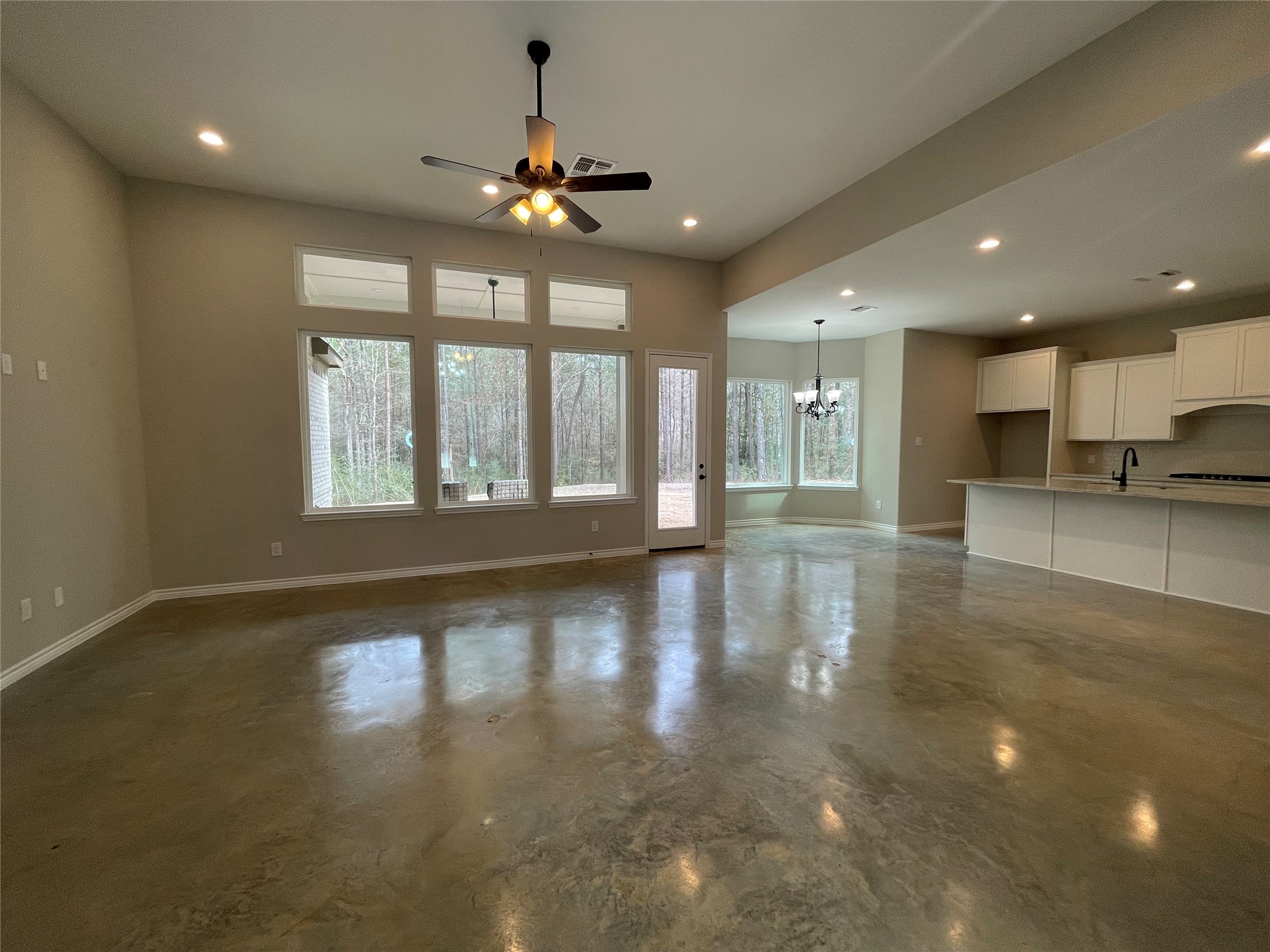 236 Dipping Vat Road Huntsville, TX 77340 - Photo 7 of 50 a view of an empty room with wooden floor and a kitchen
