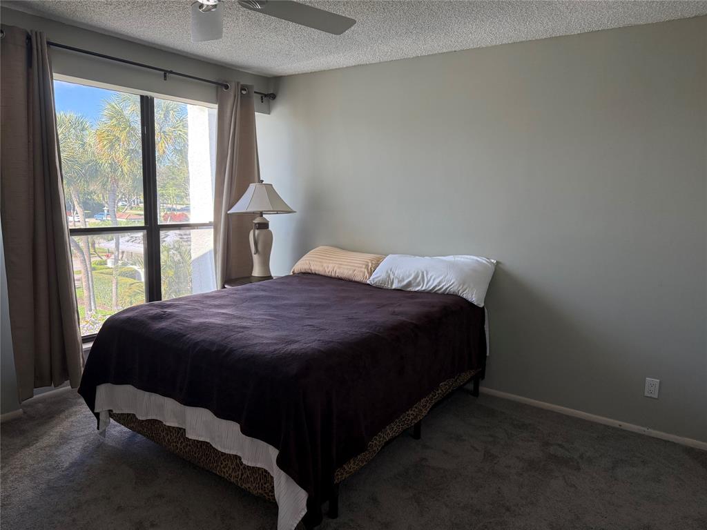 2303 Bridgewood Drive, Unit 2303 Boca Raton, FL 33434 - Photo 15 of 20 a bed sitting in a bedroom next to a window