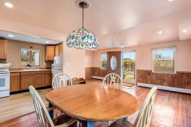a dining room filled chandelier and wooden floor
