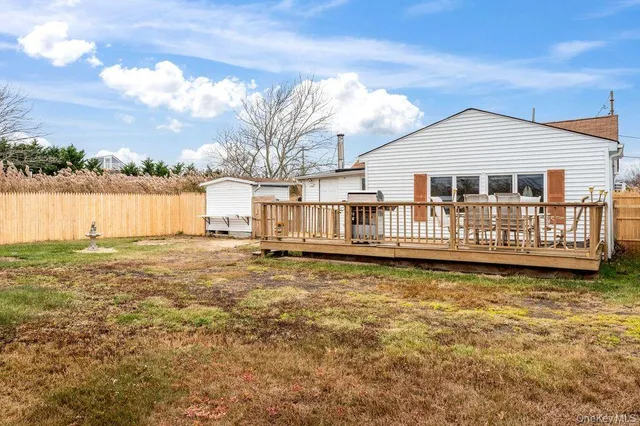 a view of a house with a wooden deck and a lake view