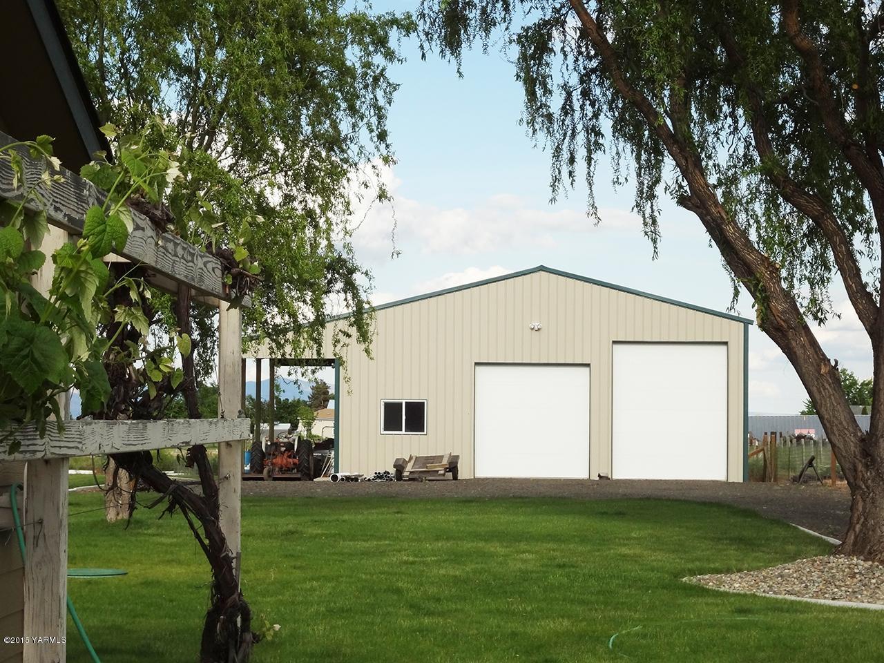 231 Rodgers Road Yakima, WA 98908 - Photo 2 of 29 a view of a white house with a big yard and large trees