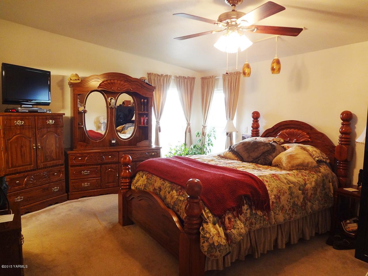 231 Rodgers Road Yakima, WA 98908 - Photo 11 of 29 a bedroom with a bed and a flat tv screen on dresser