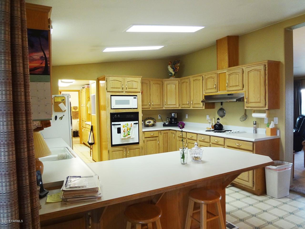 231 Rodgers Road Yakima, WA 98908 - Photo 5 of 29 a kitchen with stainless steel appliances a sink a stove top oven a counter space and cabinets