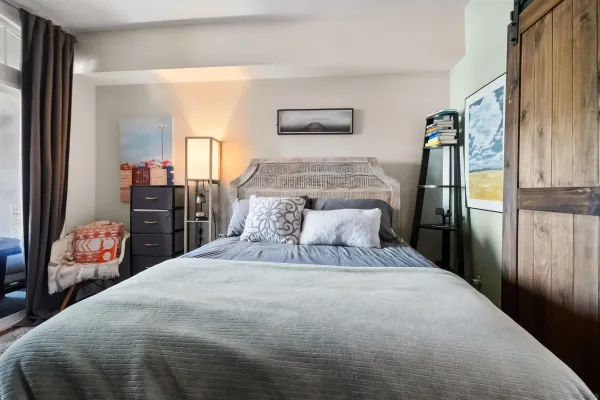 a bedroom with a bed and dresser with mirror