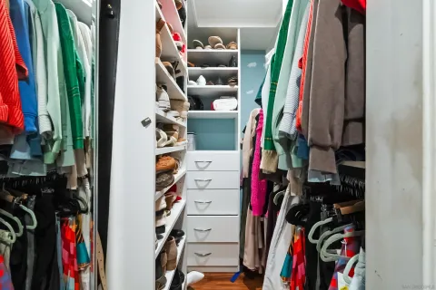 a view of walk in closet with clothes and shoes