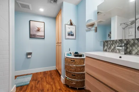 a bedroom with a bed and a lamp on dresser