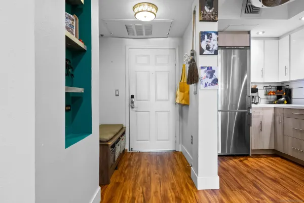 a view of hallway with wooden floor and cabinets