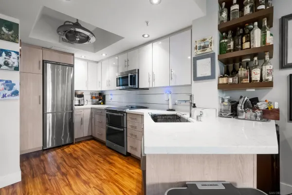 a kitchen with kitchen island a white counter top space stainless steel appliances and cabinets