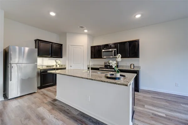 a kitchen with stainless steel appliances a refrigerator stove and microwave