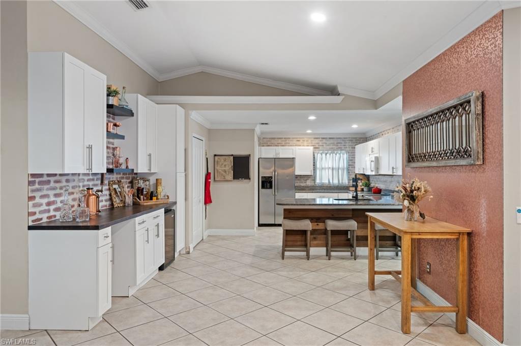 18281 Fuchsia Road Fort Myers, FL 33967 - Photo 12 of 37 a kitchen with stainless steel appliances kitchen island granite countertop a table and chairs in it