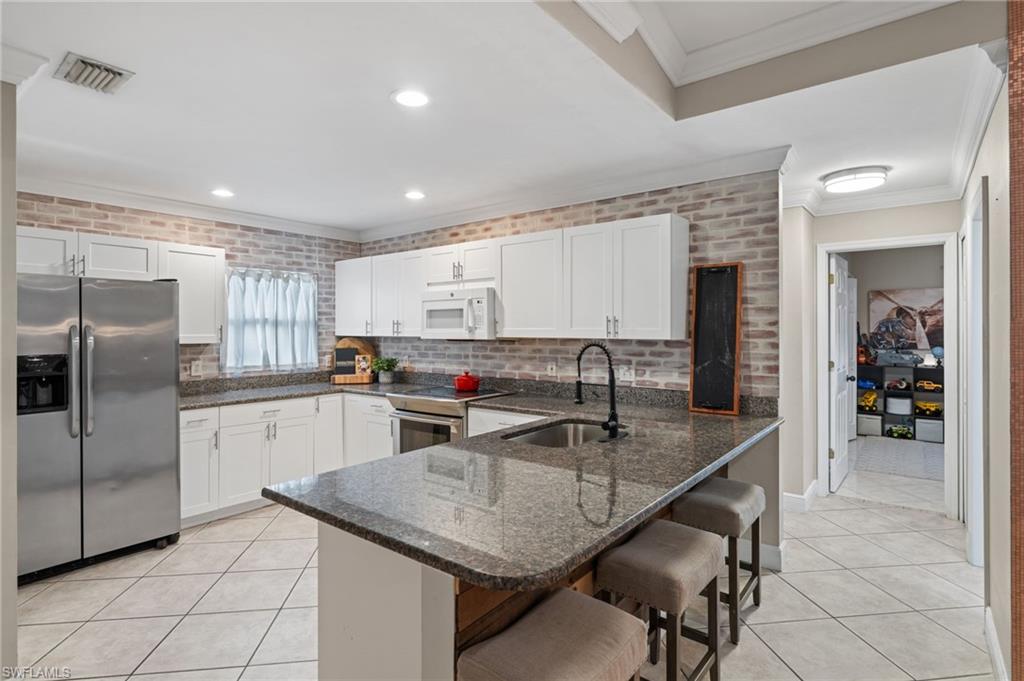 18281 Fuchsia Road Fort Myers, FL 33967 - Photo 15 of 37 a kitchen with stainless steel appliances granite countertop a sink refrigerator and cabinets