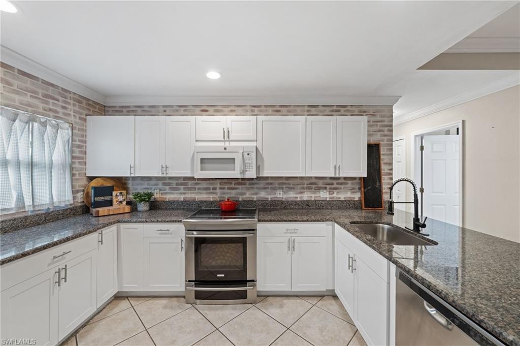 18281 Fuchsia Road Fort Myers, FL 33967 - Photo 16 of 37 a kitchen with stainless steel appliances granite countertop a sink stove and cabinets