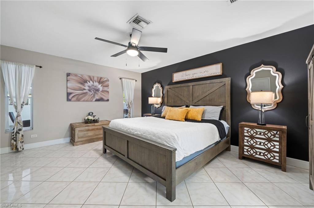 18281 Fuchsia Road Fort Myers, FL 33967 - Photo 17 of 37 a bedroom with a bed and a chandelier