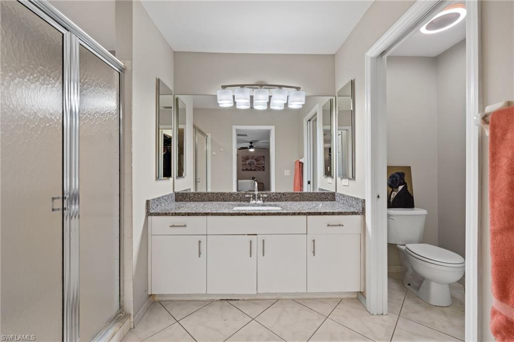 18281 Fuchsia Road Fort Myers, FL 33967 - Photo 19 of 37 a spacious bathroom with a granite countertop toilet a sink and a mirror