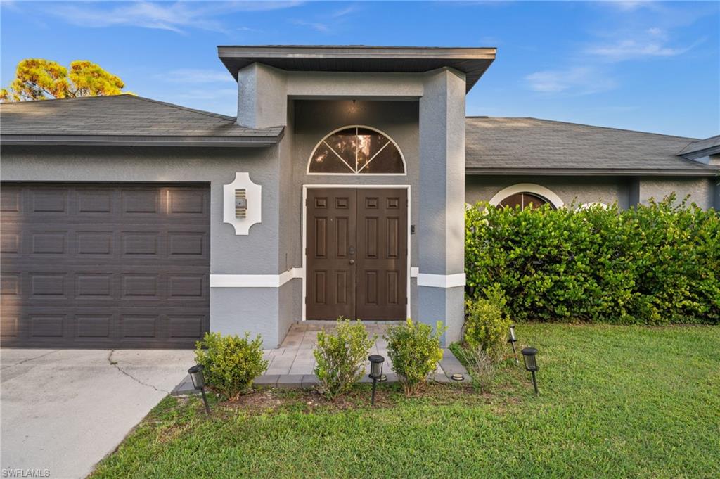 18281 Fuchsia Road Fort Myers, FL 33967 - Photo 2 of 37 a front view of a house with garden