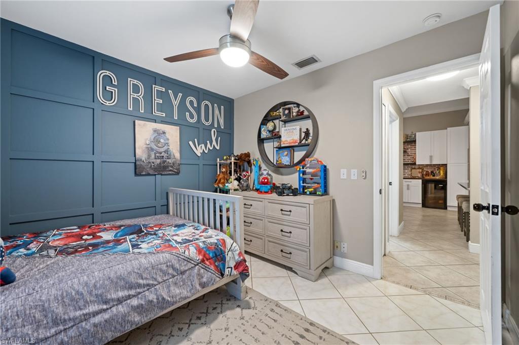 18281 Fuchsia Road Fort Myers, FL 33967 - Photo 23 of 37 a bedroom with a bed and a chandelier