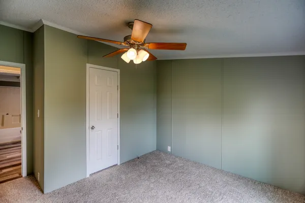 an empty room with a window and a fan