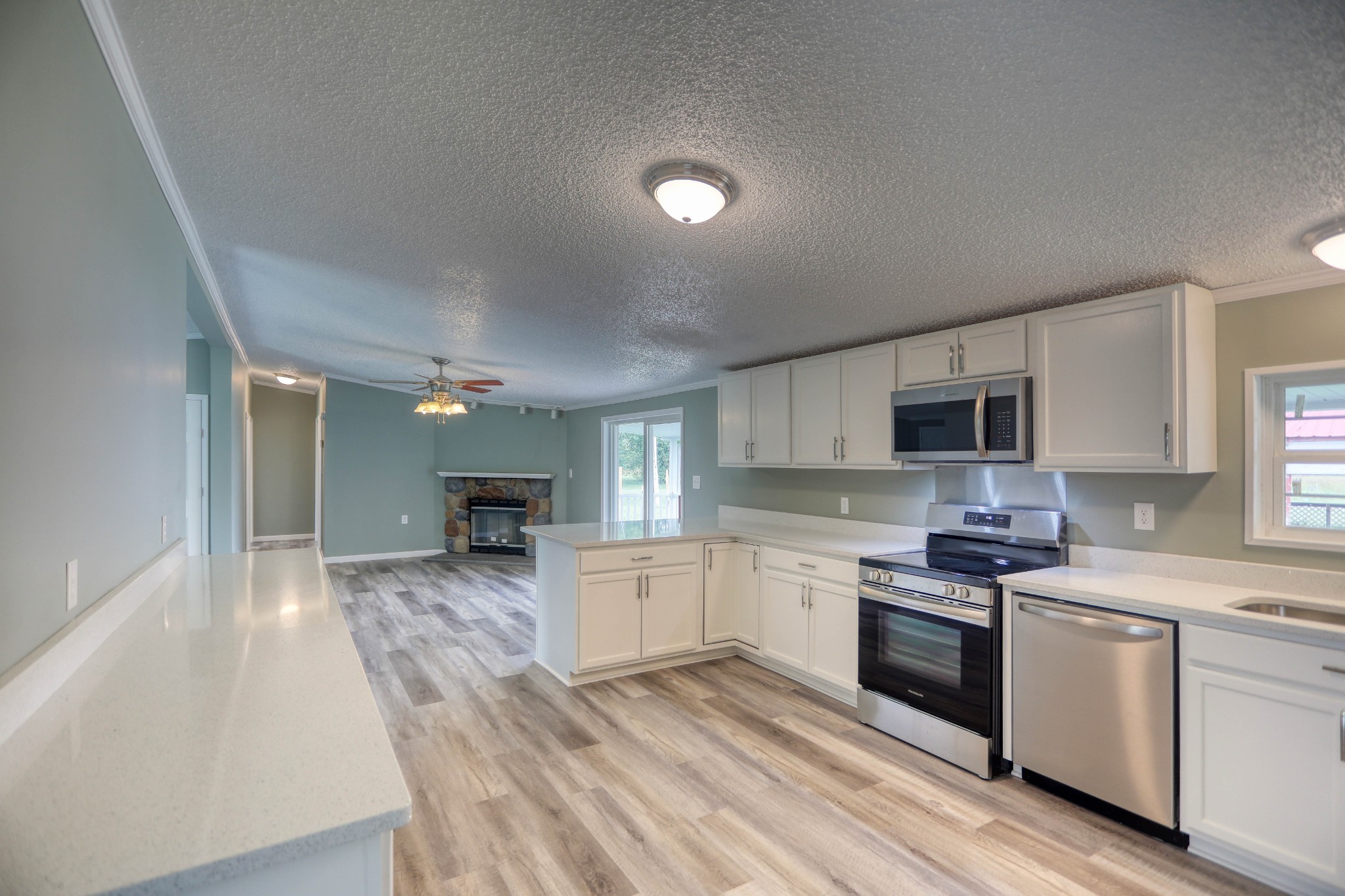 1834 Oak Grove Church Road Adolphus, KY 42120 - Photo 2 of 32 a kitchen with granite countertop a stove top oven a sink dishwasher and white cabinets with wooden floor