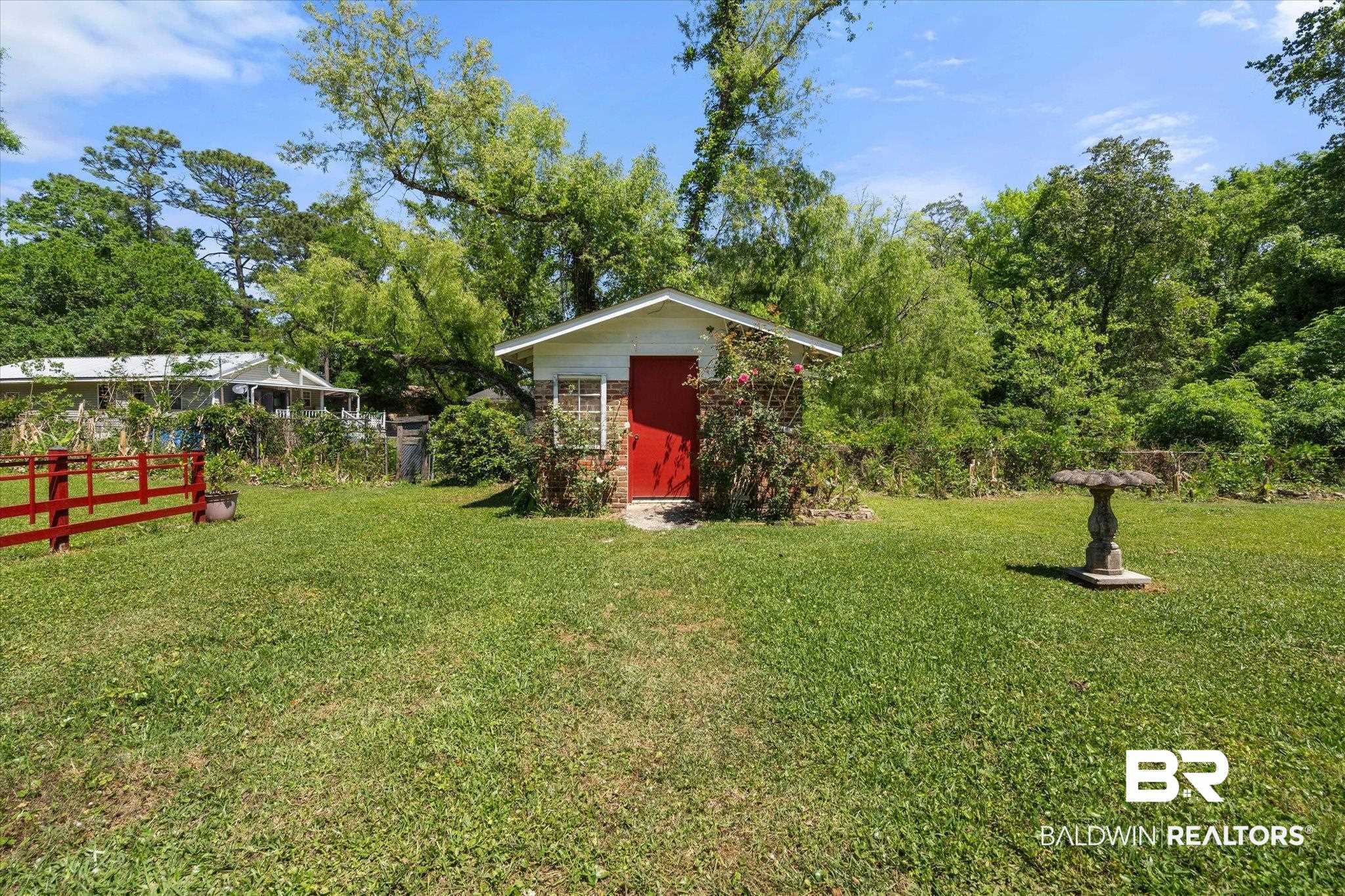 706 Sutherland Drive Chickasaw, AL 36611 - Photo 27 of 33 View of yard with a storage unit, an outbuilding, and fence