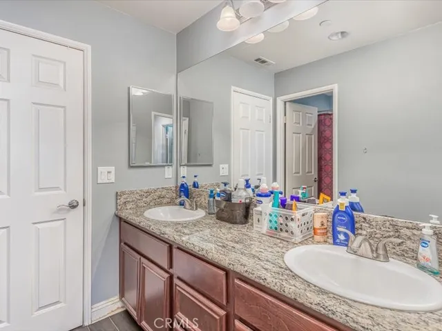 a bathroom with double vanity sinks and a mirror