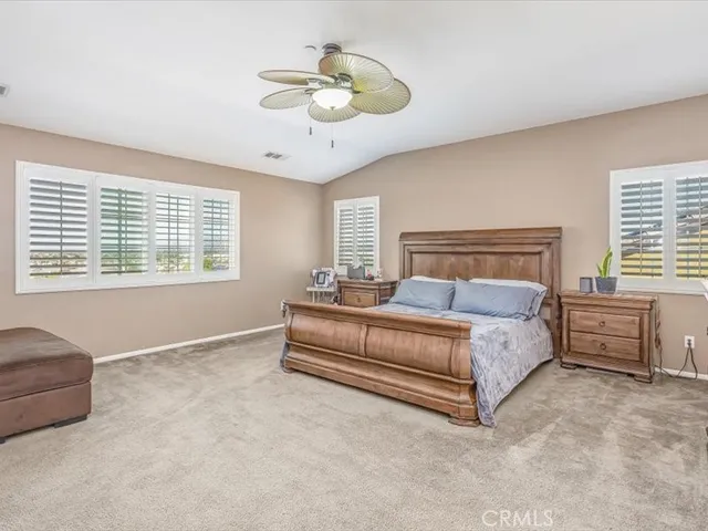 a spacious bedroom with a bed and a chandelier