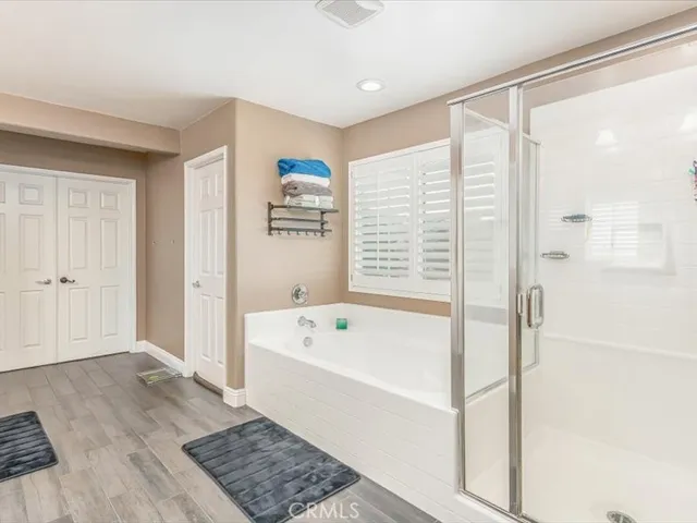 a bathroom with a bathtub a shower a sink and a window