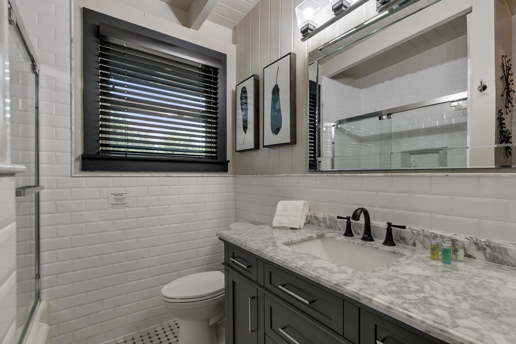 48 Kneese Road Fredericksburg, TX 78624 - Photo 11 of 43 a bathroom with a granite countertop toilet sink and mirror