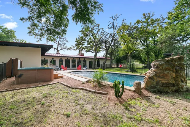 a view of a house with swimming pool yard and a porch