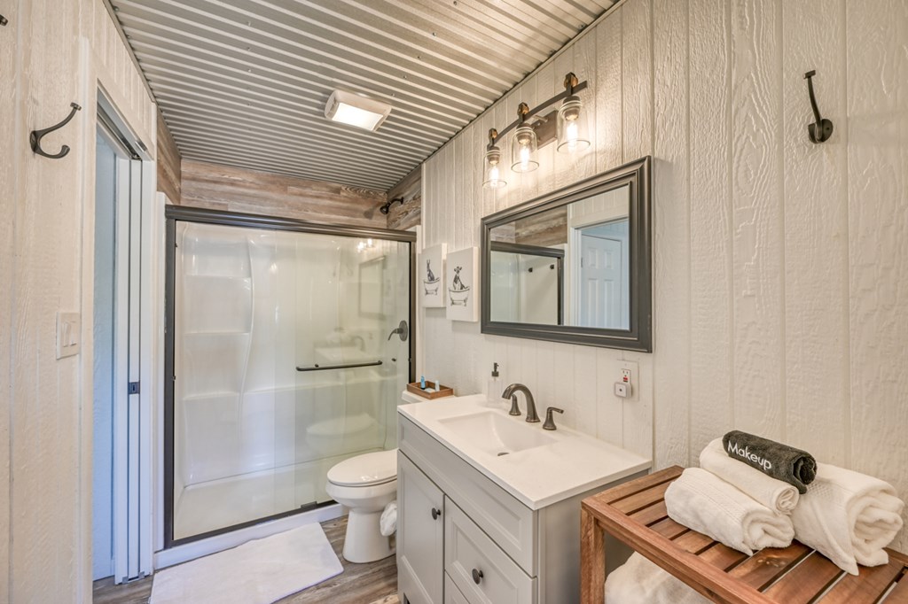 48 Kneese Road Fredericksburg, TX 78624 - Photo 29 of 43 a bathroom with a granite countertop sink toilet a mirror and shower