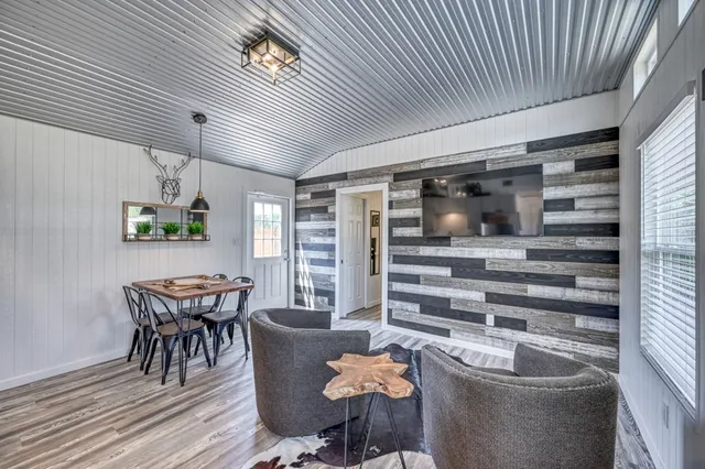 a kitchen with stainless steel appliances granite countertop a stove a refrigerator a sink dishwasher a dining table and chairs with wooden floor