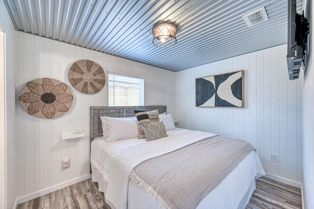 48 Kneese Road Fredericksburg, TX 78624 - Photo 39 of 43 a bedroom with a bed and a chandelier