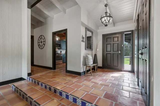 a view of a hallway with wooden floor and a glass door