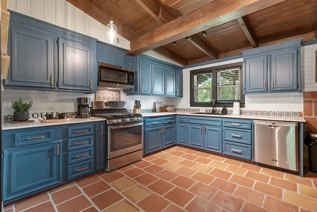 a kitchen with stainless steel appliances granite countertop wooden cabinets a stove top oven a sink and dishwasher