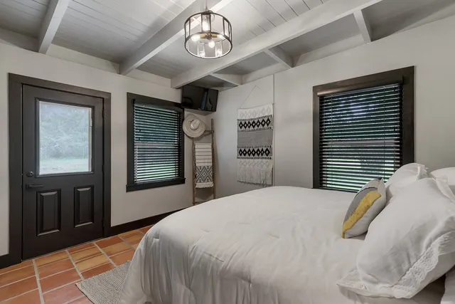 a bedroom with a bed and a large window