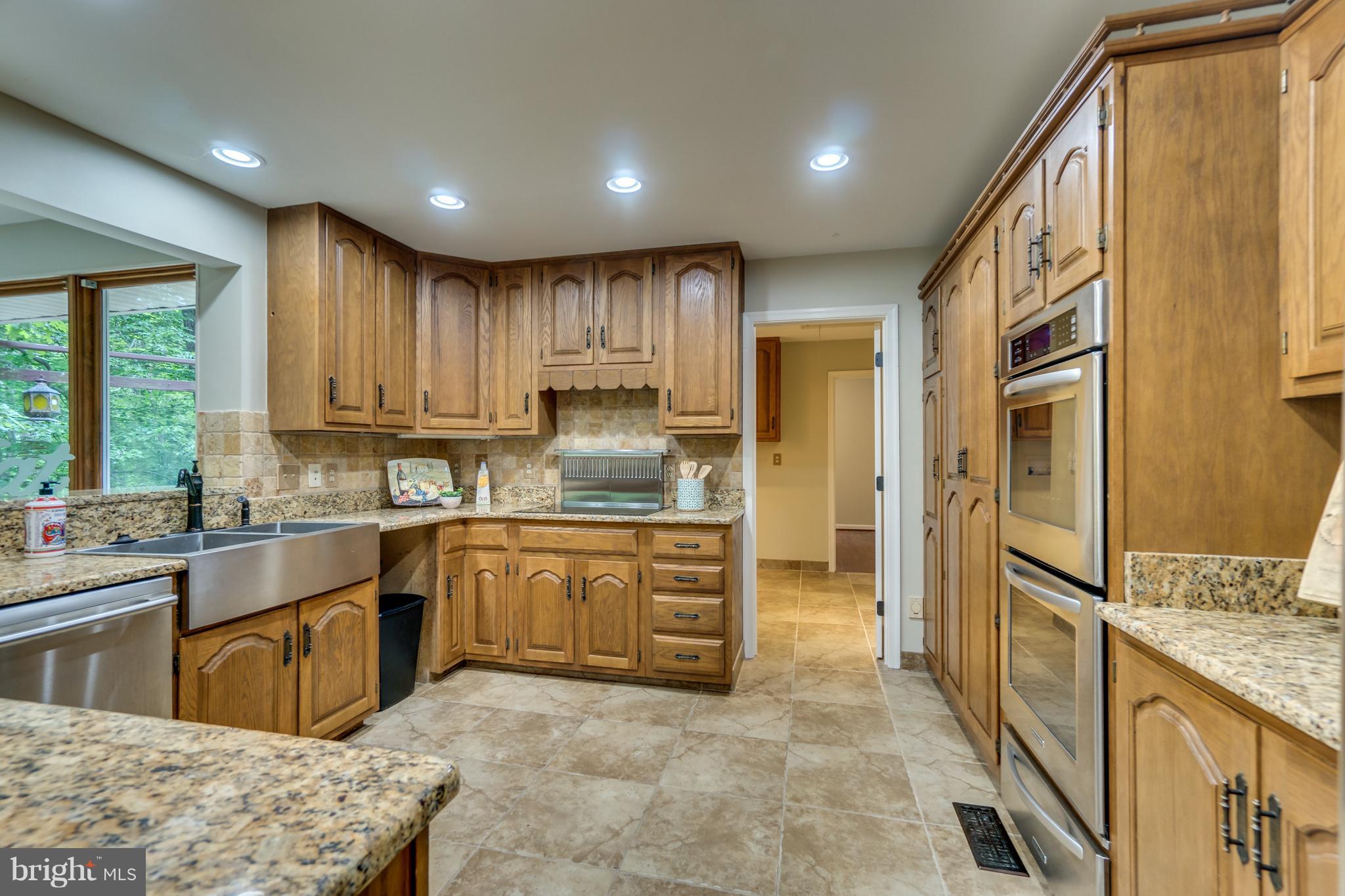 117 Bluff Point Road Fredericksburg, VA 22407 - Photo 13 of 30 a kitchen with stainless steel appliances granite countertop a refrigerator a sink dishwasher a stove and a dining table with wooden floor