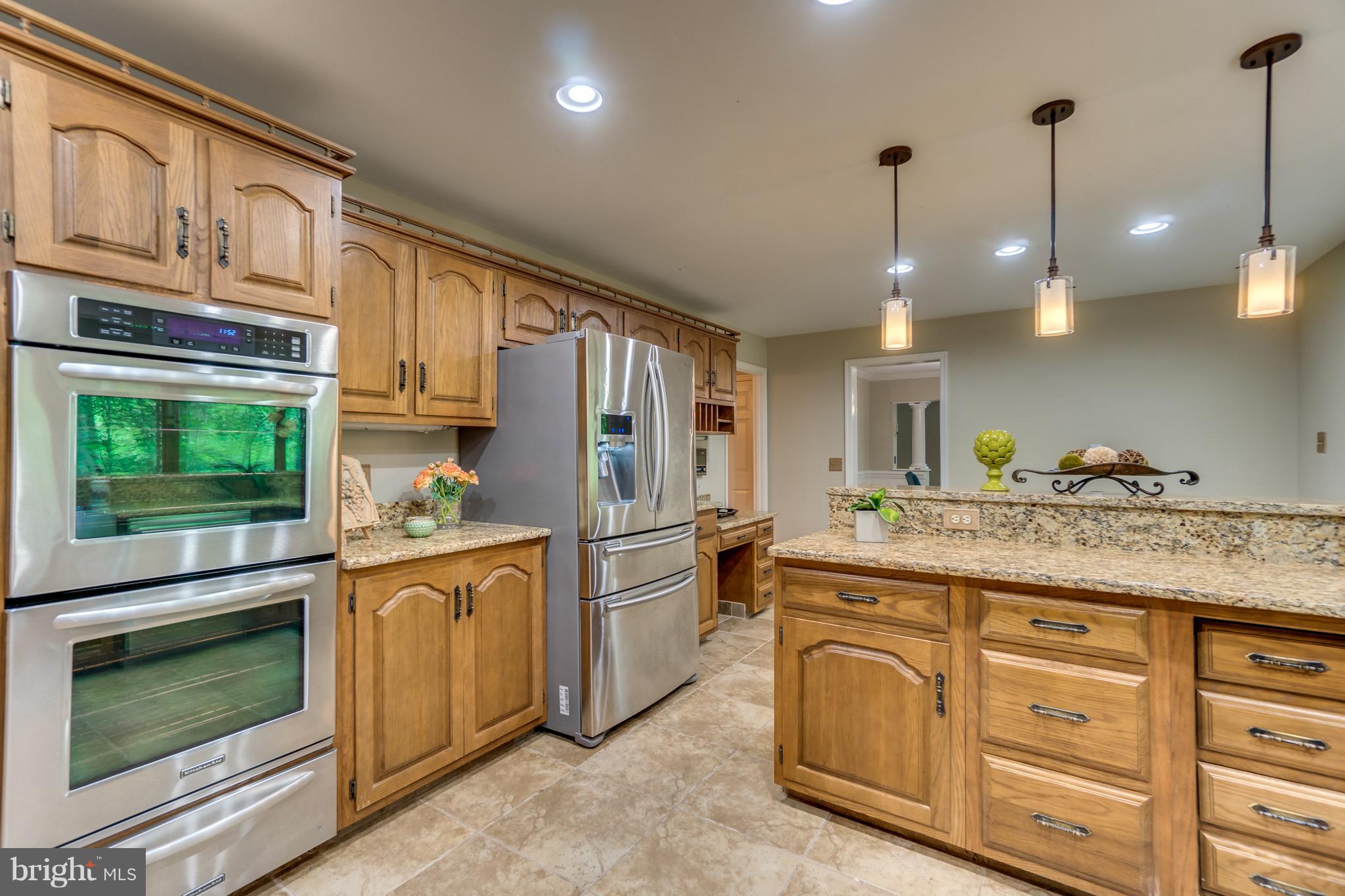 117 Bluff Point Road Fredericksburg, VA 22407 - Photo 17 of 30 a kitchen with kitchen island granite countertop a stove a sink and dishwasher with cabinets