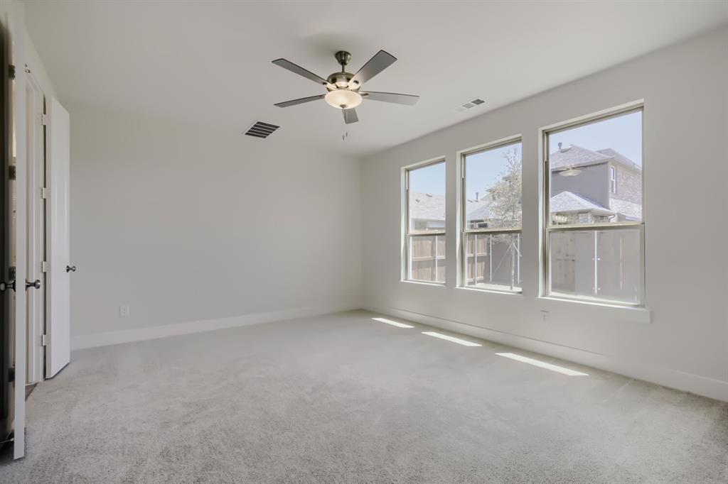 828 Stone Grv Road Lavon, TX 75166 - Photo 10 of 27 Spacious room featuring three large windows, light gray carpeting, and a ceiling fan with integrated lighting