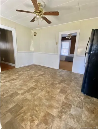 an empty room with a mirror and fan