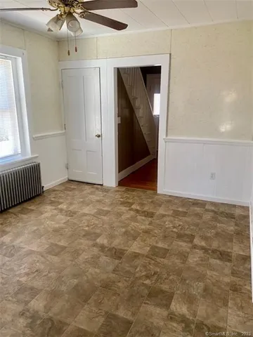 an empty room with a mirror and fan