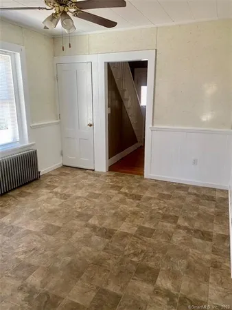 an empty room with a mirror and fan