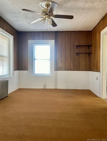 an empty room with a window and a ceiling fan