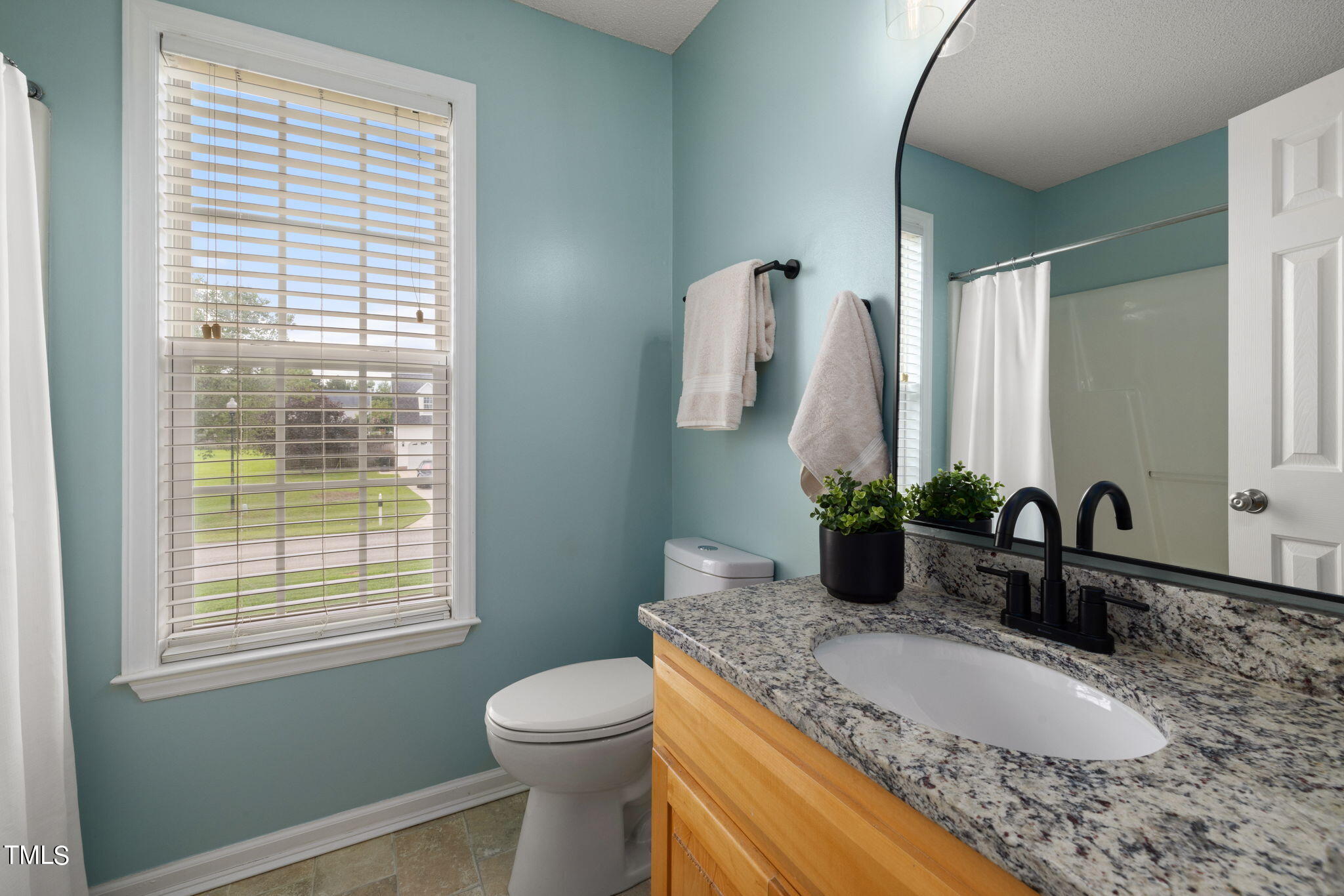 1500 Harvey Johnson Road Raleigh, NC 27603 - Photo 21 of 42 a bathroom with a granite countertop sink and a mirror