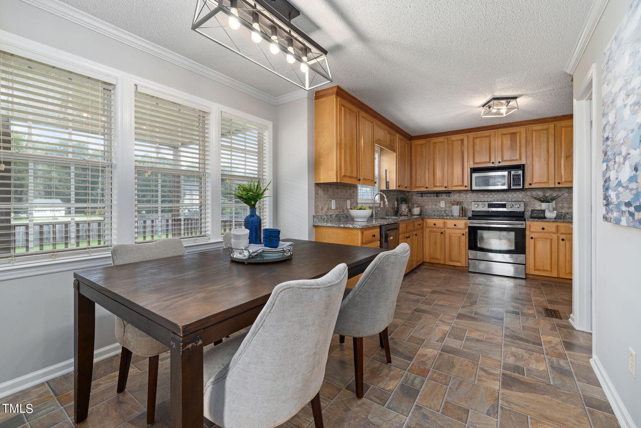 1500 Harvey Johnson Road Raleigh, NC 27603 - Photo 7 of 42 a open kitchen with stainless steel appliances granite countertop a stove a refrigerator a kitchen island a table and chairs